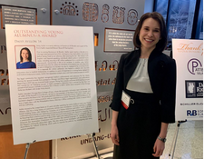 Senior Attorney Daisy Ayllón in front of her poster at the award ceremony.